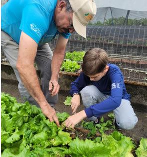 Aluno e instrutor na horta escolar