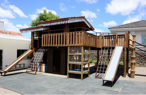 Playground de madeira com escorregadores e rampas