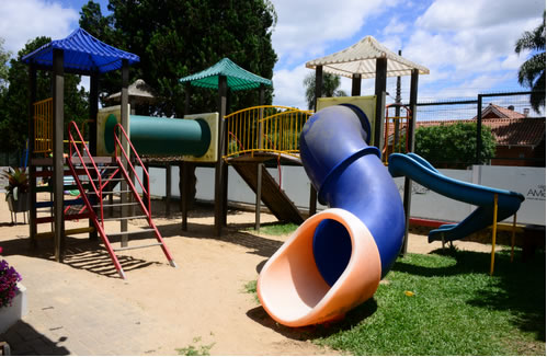 Playground colorido com escorregador em tubo azul