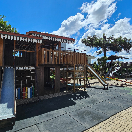 Playground de madeira com escorregadores e rampas